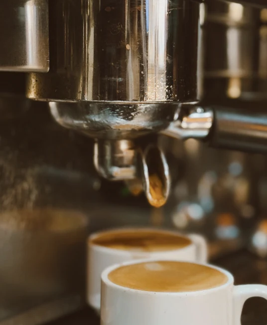A double espresso being pulled from the machine into two cups