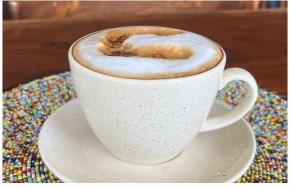 A cappuccino on a colourful beaded mat at Coffee Culture