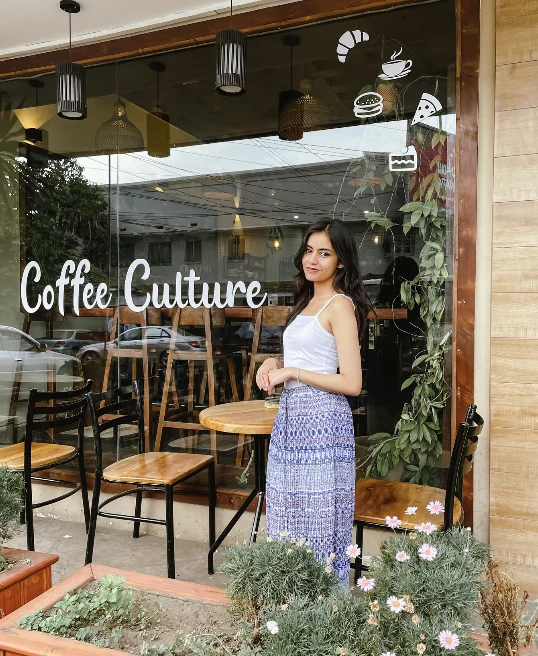 The Coffee Culture entrance with greenery and the name painted on the window